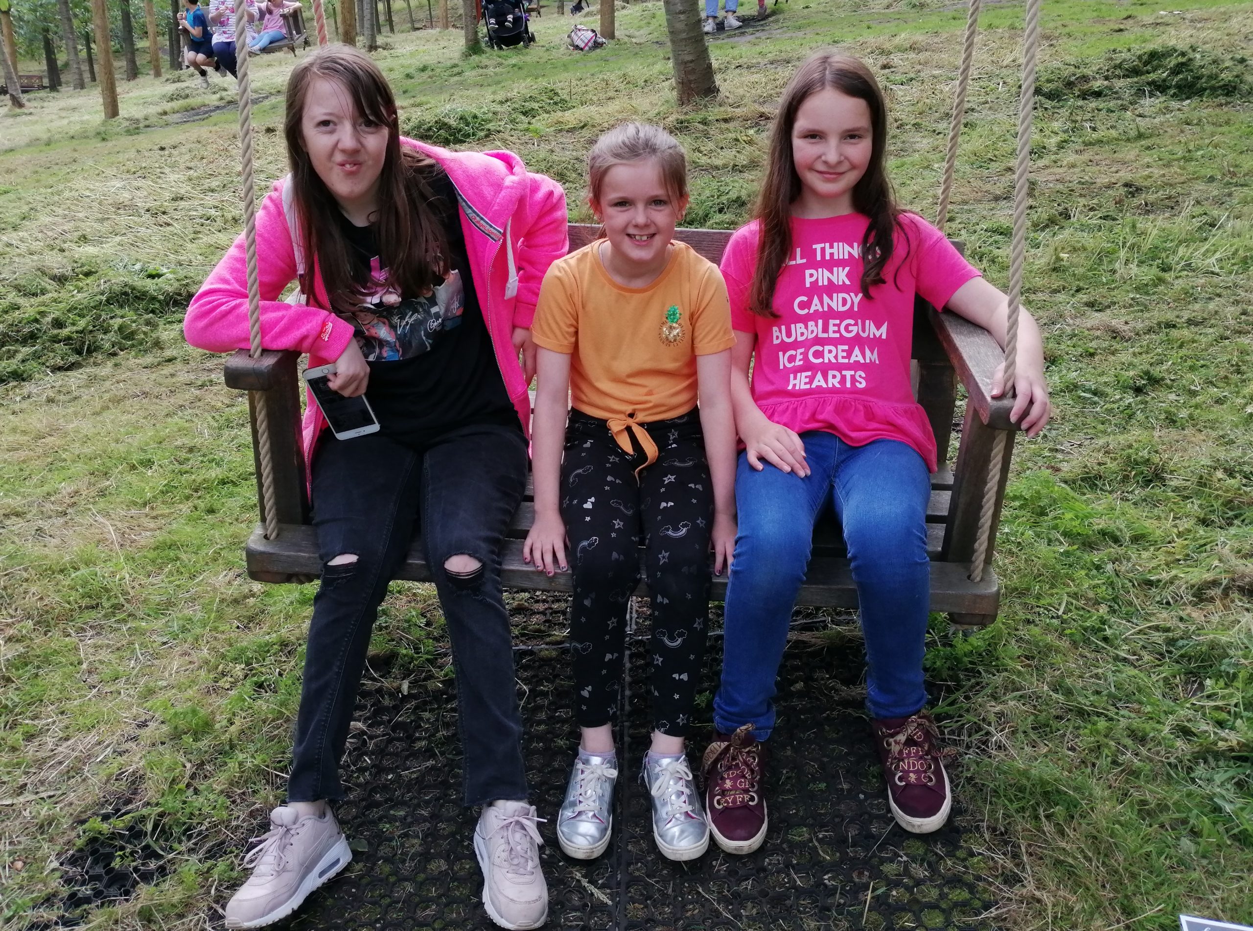 Siblings Support Girls on Swing